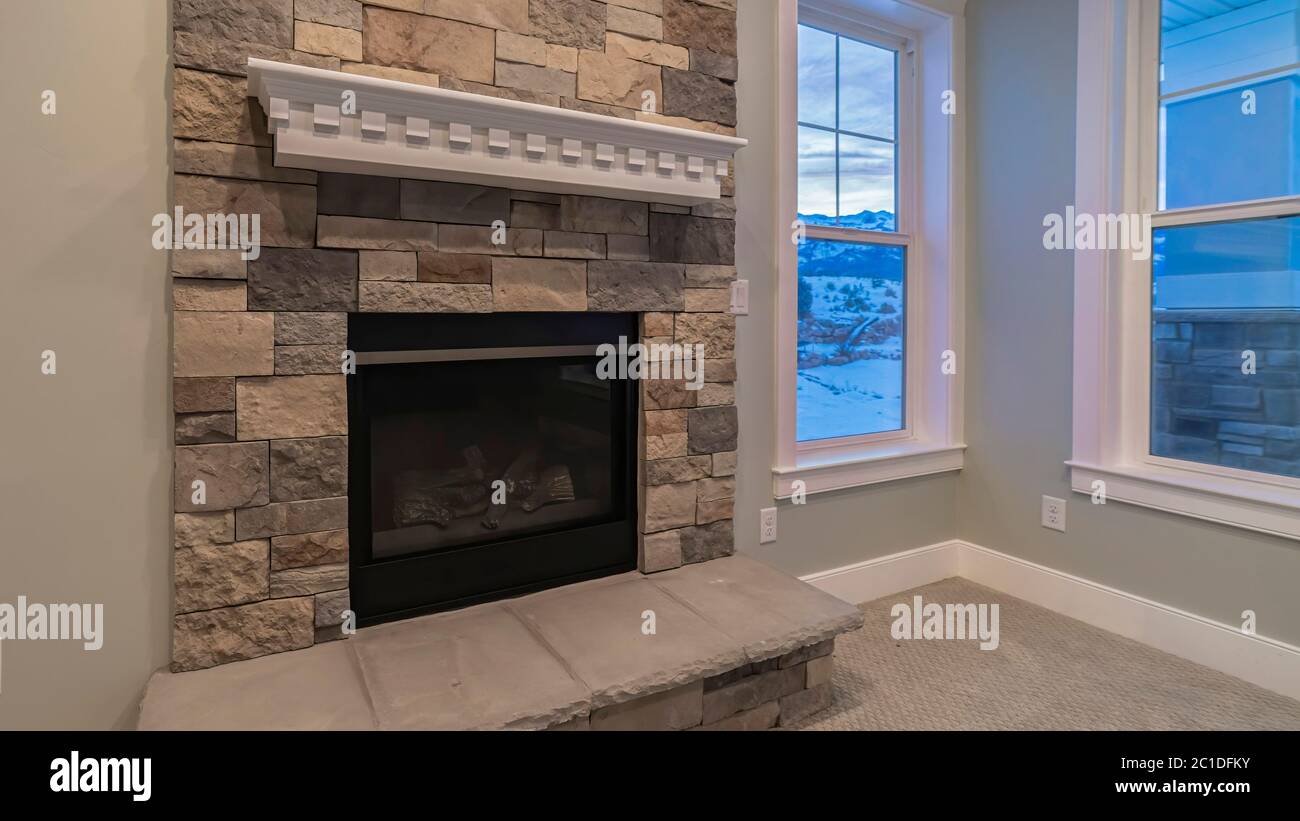 Panorama crop Modern fireplace and decorative shelf against stone brick accent wall of home