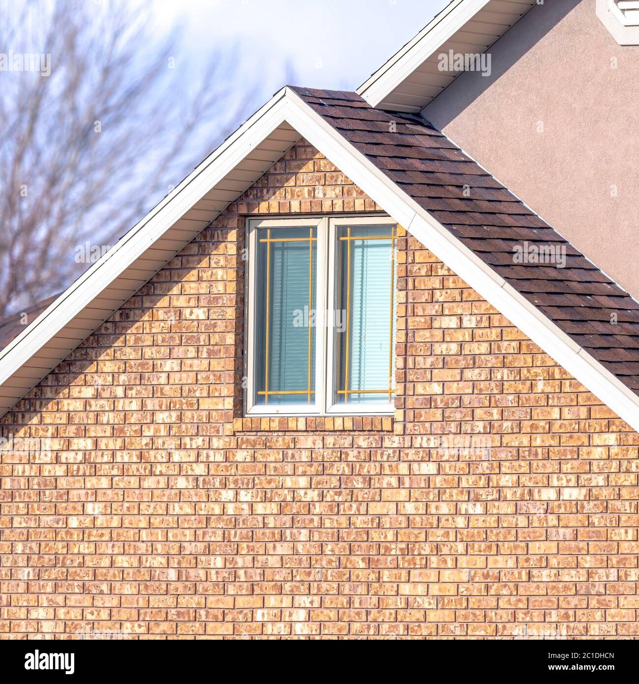 Square Close up of a home exterior with sunlit pitched roof over window
