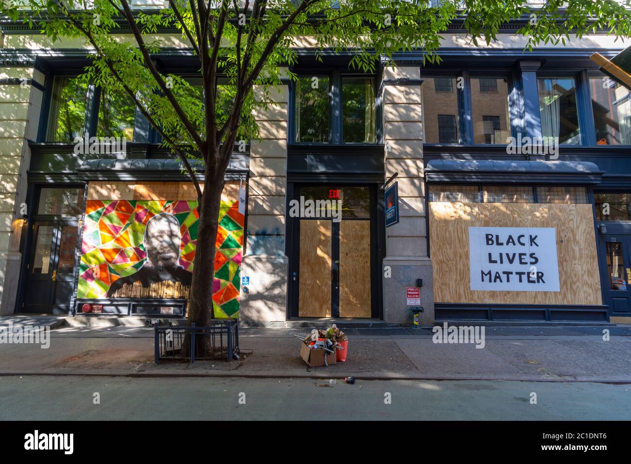 Artists draw Portrait of Jorge Floyd on the Barricade Board of stores windows in SOHO at New York City NY USA. Stock Photo