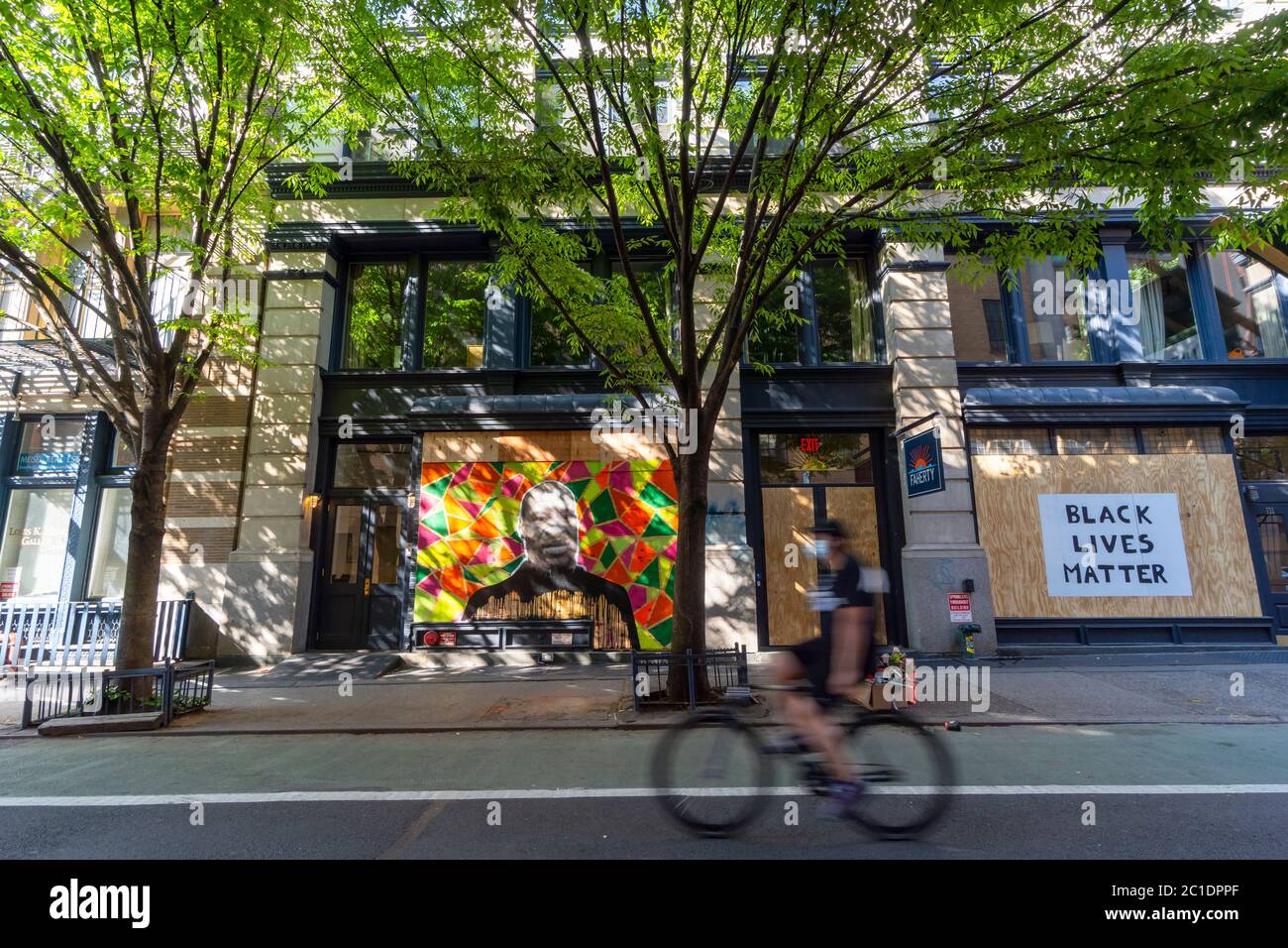 Artists draw Portrait of Jorge Floyd on the Barricade Board of stores windows in SOHO at New York City NY USA. Stock Photo