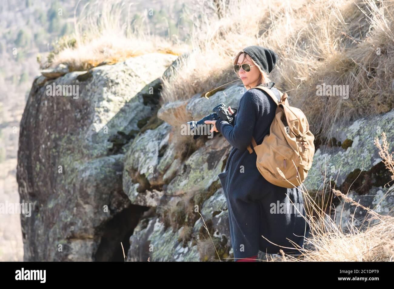 Woman hipster-photographer with dslr camera. Stylish girl in sunglasses with a camera on the nature Stock Photo