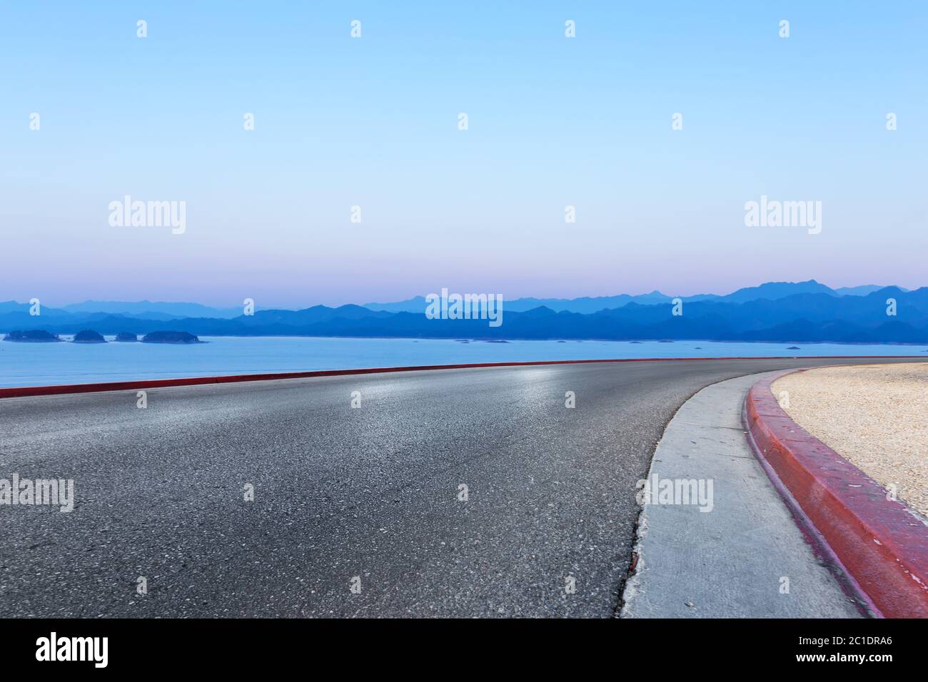 asphalt road and blue sky with white clouds by the lake Stock Photo - Alamy