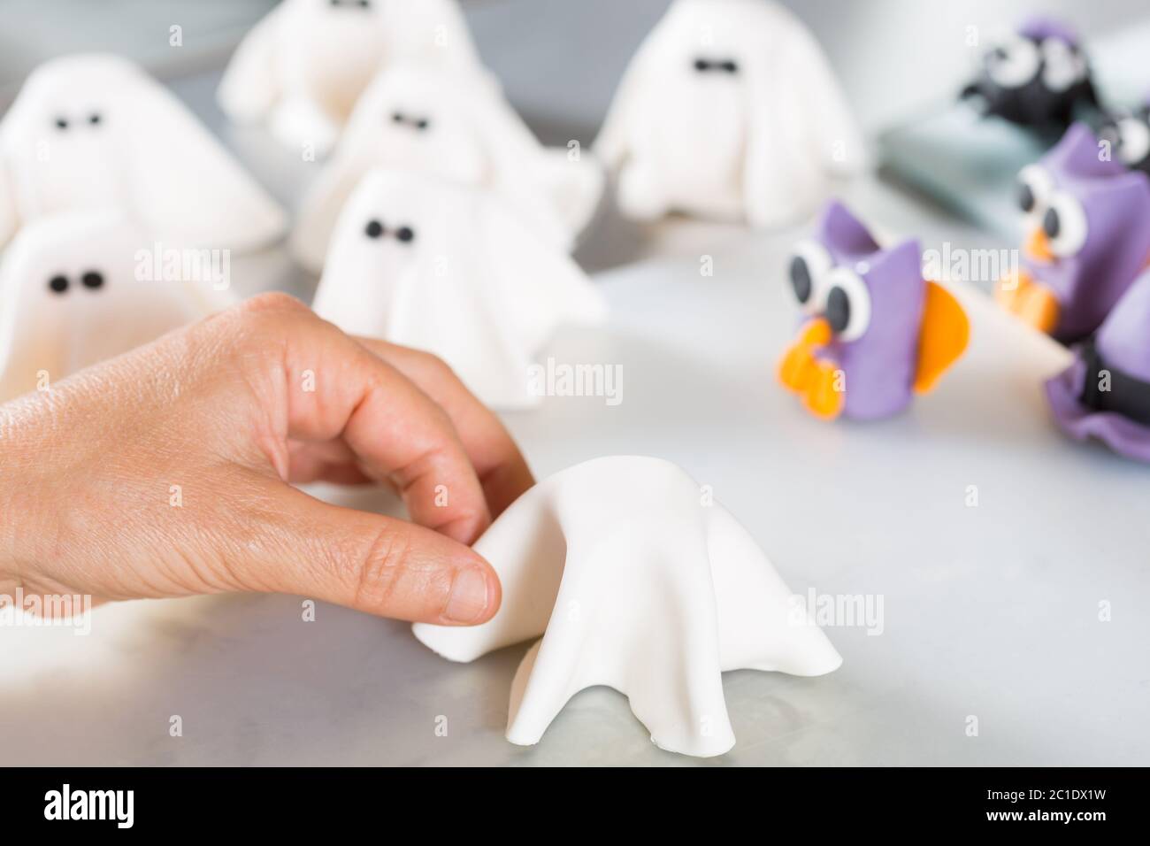 Confectioner working on the figures of Halloween with fondant paste Stock Photo