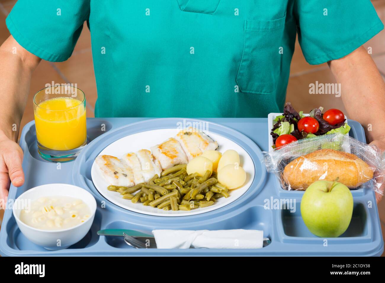 Health professional with a tray of food to a patient Stock Photo
