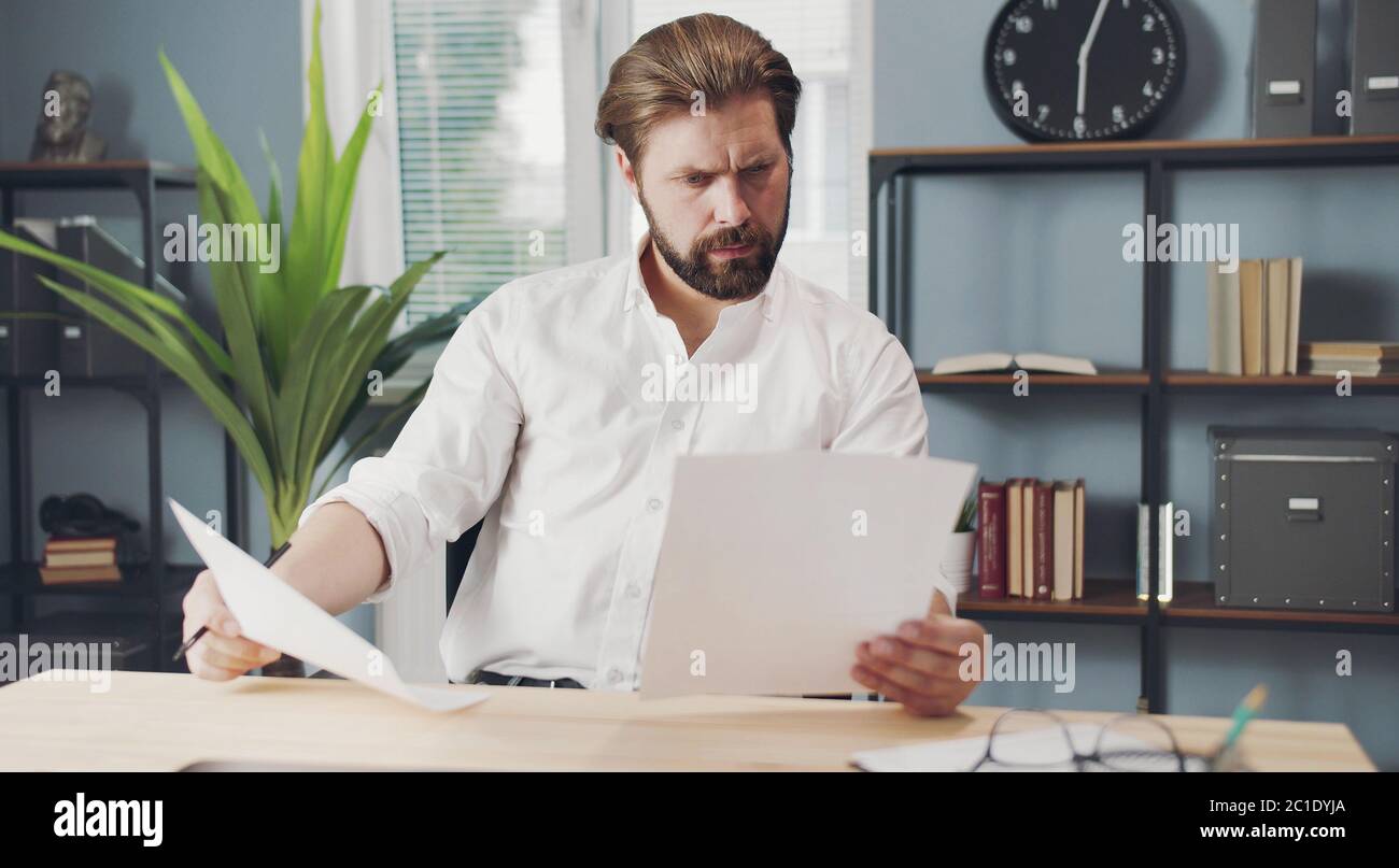 Concentrated businessman holding papers Stock Photo