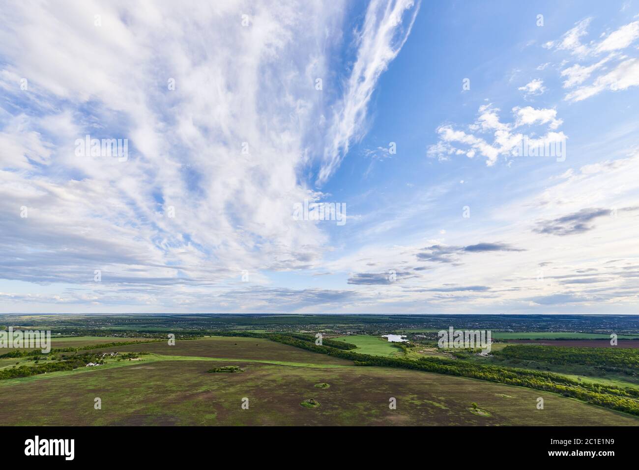 Aerial view of green fields under a blue sky with clouds in the ...