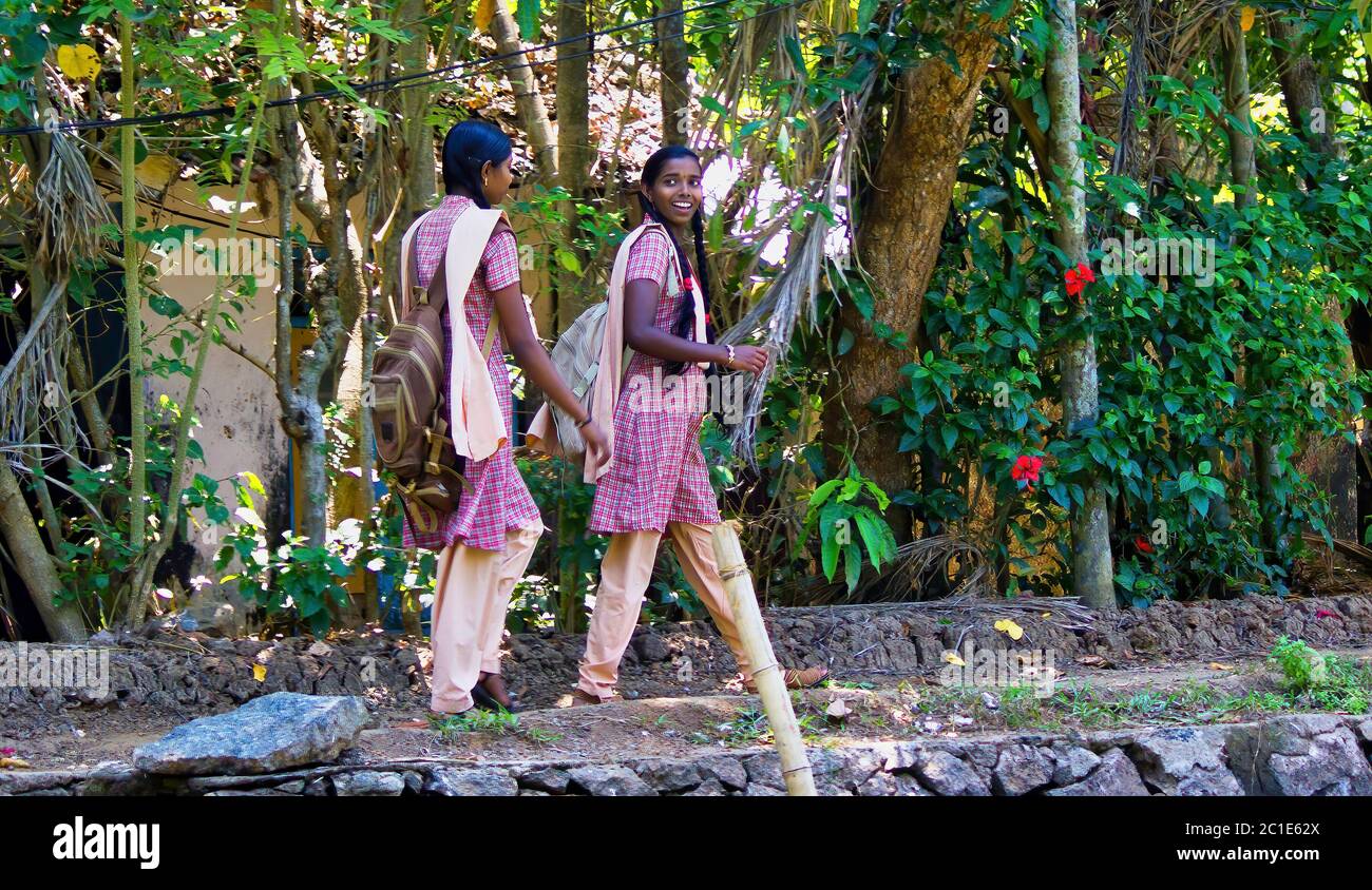Alleppey, India - March 11, 2014: Girls in uniform going home after school in rural town located in Kerala state of southern India Stock Photo