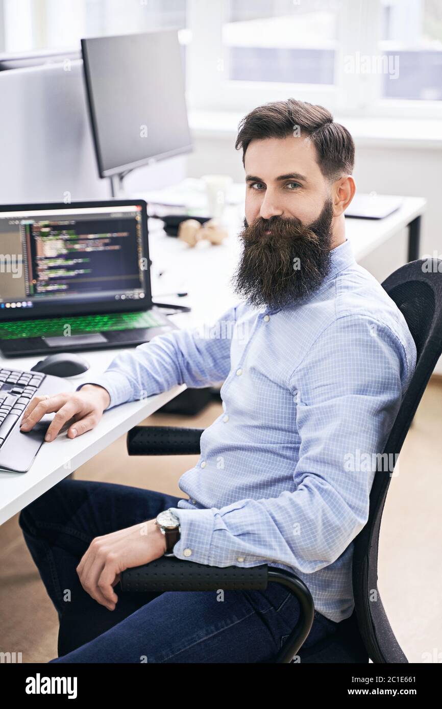 Cheerful senior programmer developer working in IT office, sitting at desk  and coding, working on a project in software development company or startup  Stock Photo - Alamy