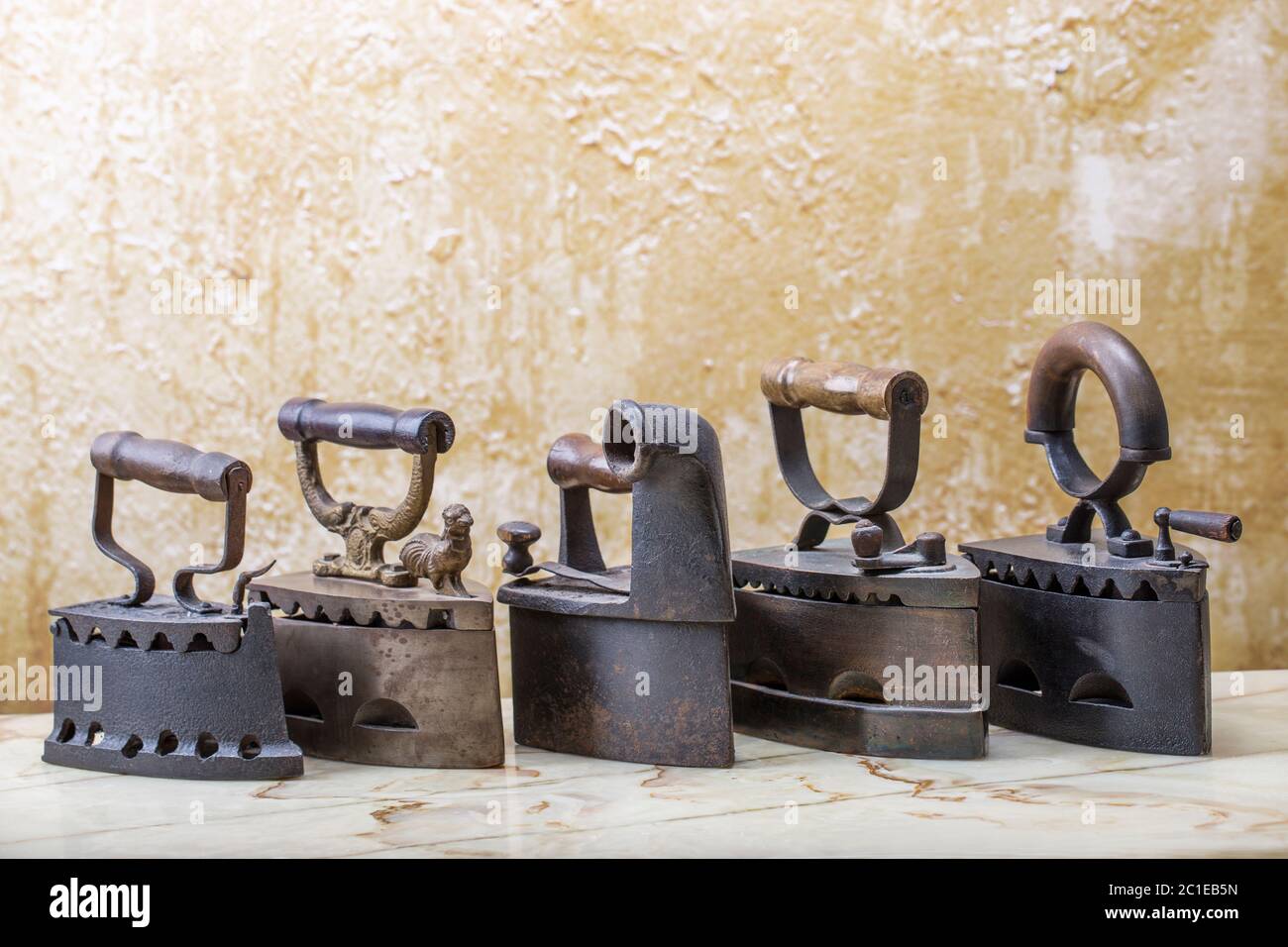 Photo of the antique irons on the vintage stucco background Stock Photo