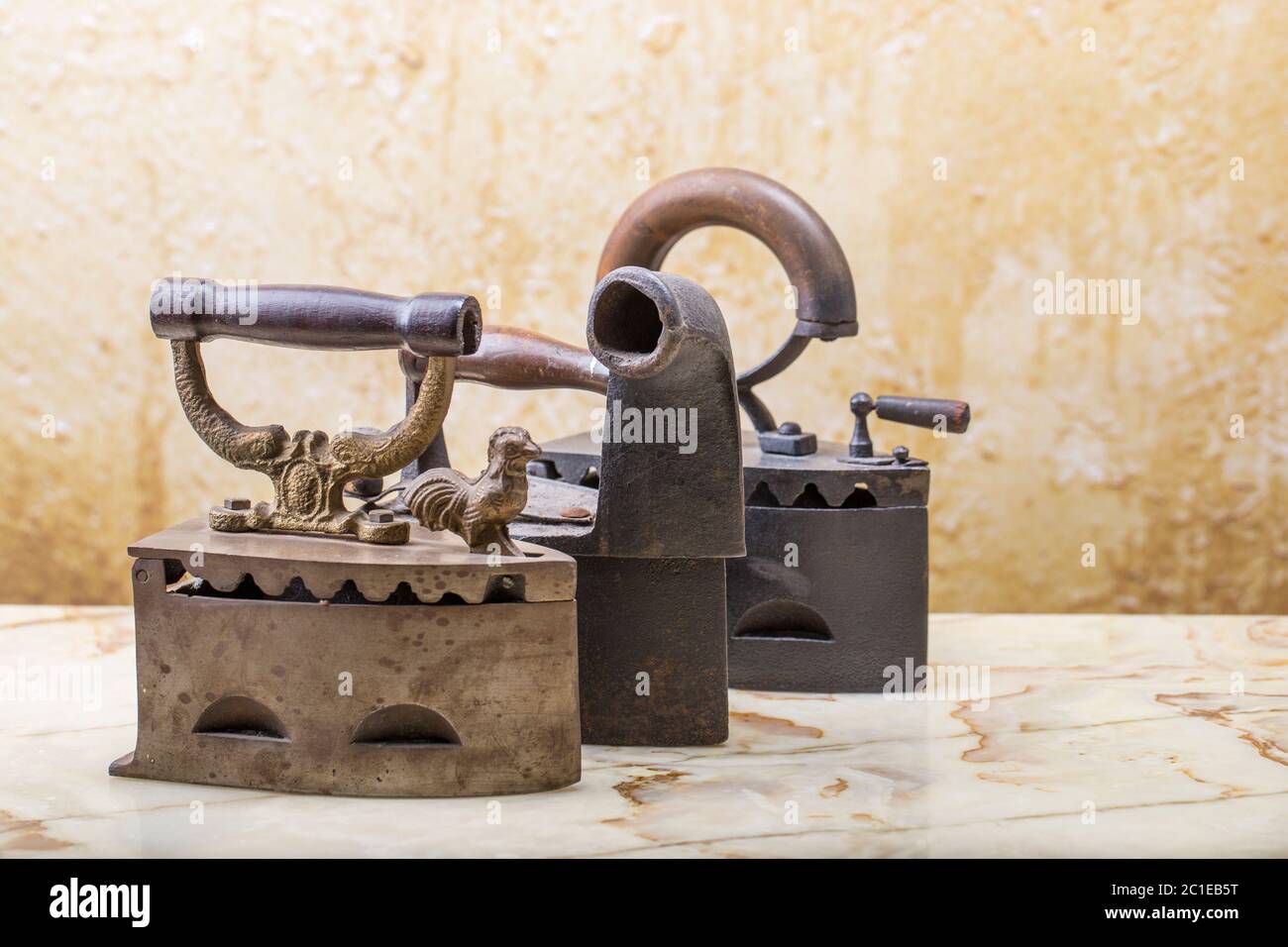 Photo of the antique irons on the vintage stucco background Stock Photo