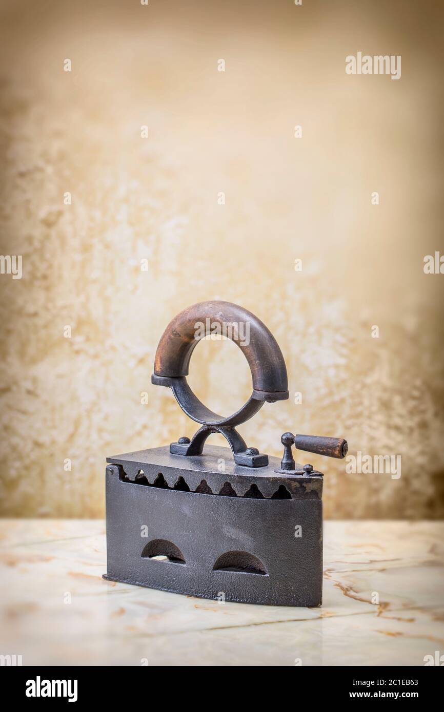 Photo of the antique iron on the vintage stucco background Stock Photo