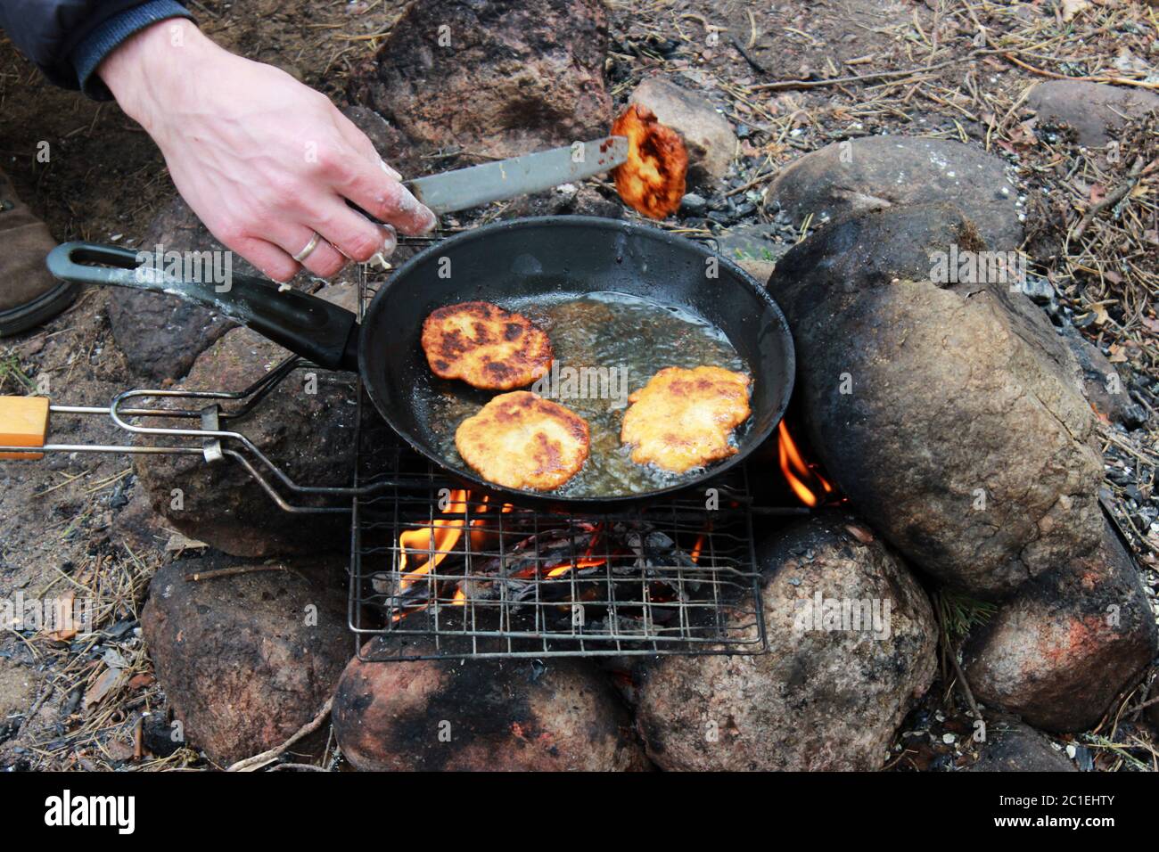 pancakes, cooked in a frying pan on an open fire in a hike in the summer Stock Photo