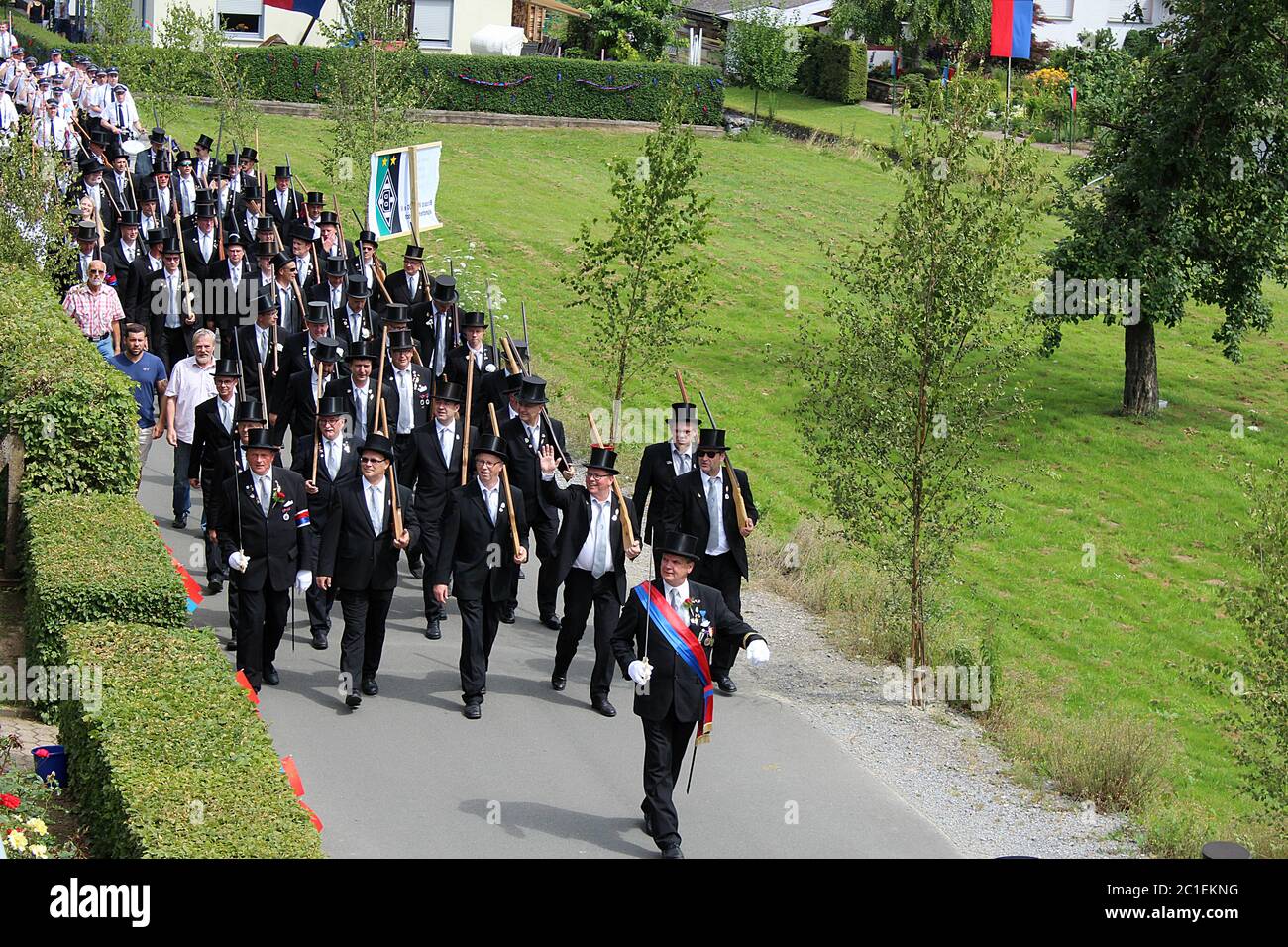 Festive procession of the associations of marksmen through residential area at a traditional German Schützenfest (marksmen's festival) in Lügde. Stock Photo