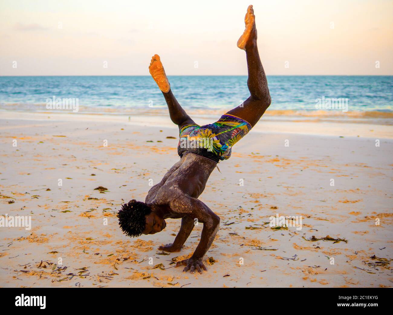 young-attractive-muscular-and-strong-athletic-black-african-man-at-the-white-sand-beach-training-acrobatics-and-handstand-gymnastics-beach-performance-2C1EKYG.jpg