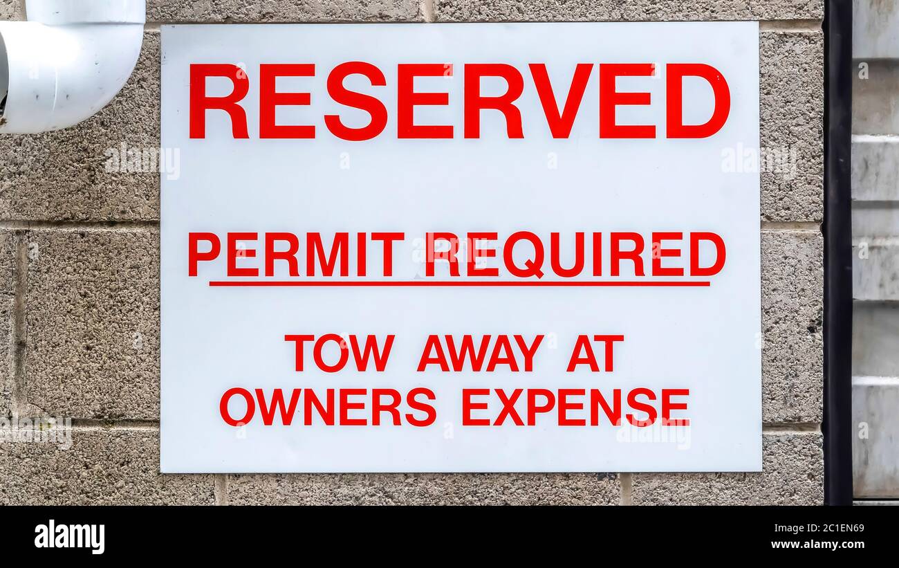 Panorama Reserved sign and downspout against wall of building and corrugated garage door Stock Photo