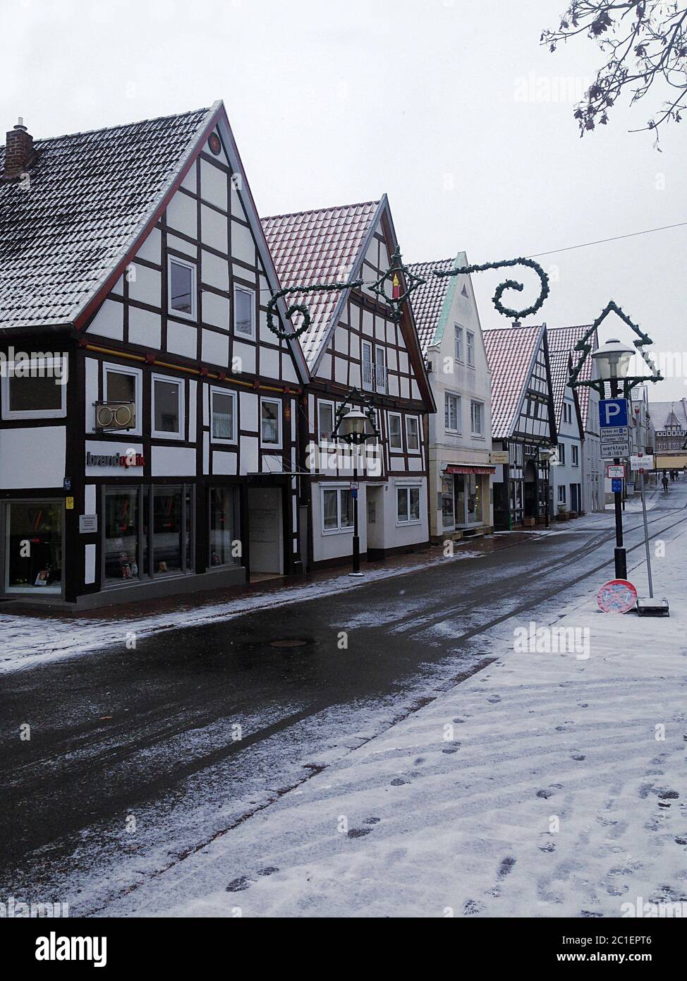 Snowy historic street on cloudy day in downtown Blomberg,  Westphalia, Germany with Christmas decorations. Stock Photo