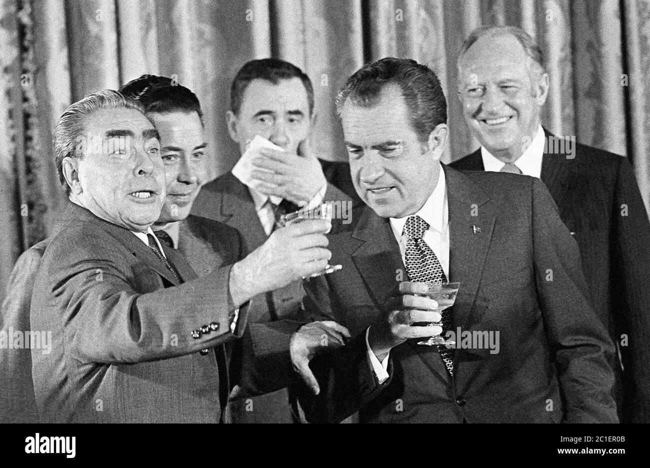 US President Nixon reaches to clink his glass with that of Henry Kissinger in Moscow in 1972 with USSR leader Leonid Brezhnev in the background Stock Photo