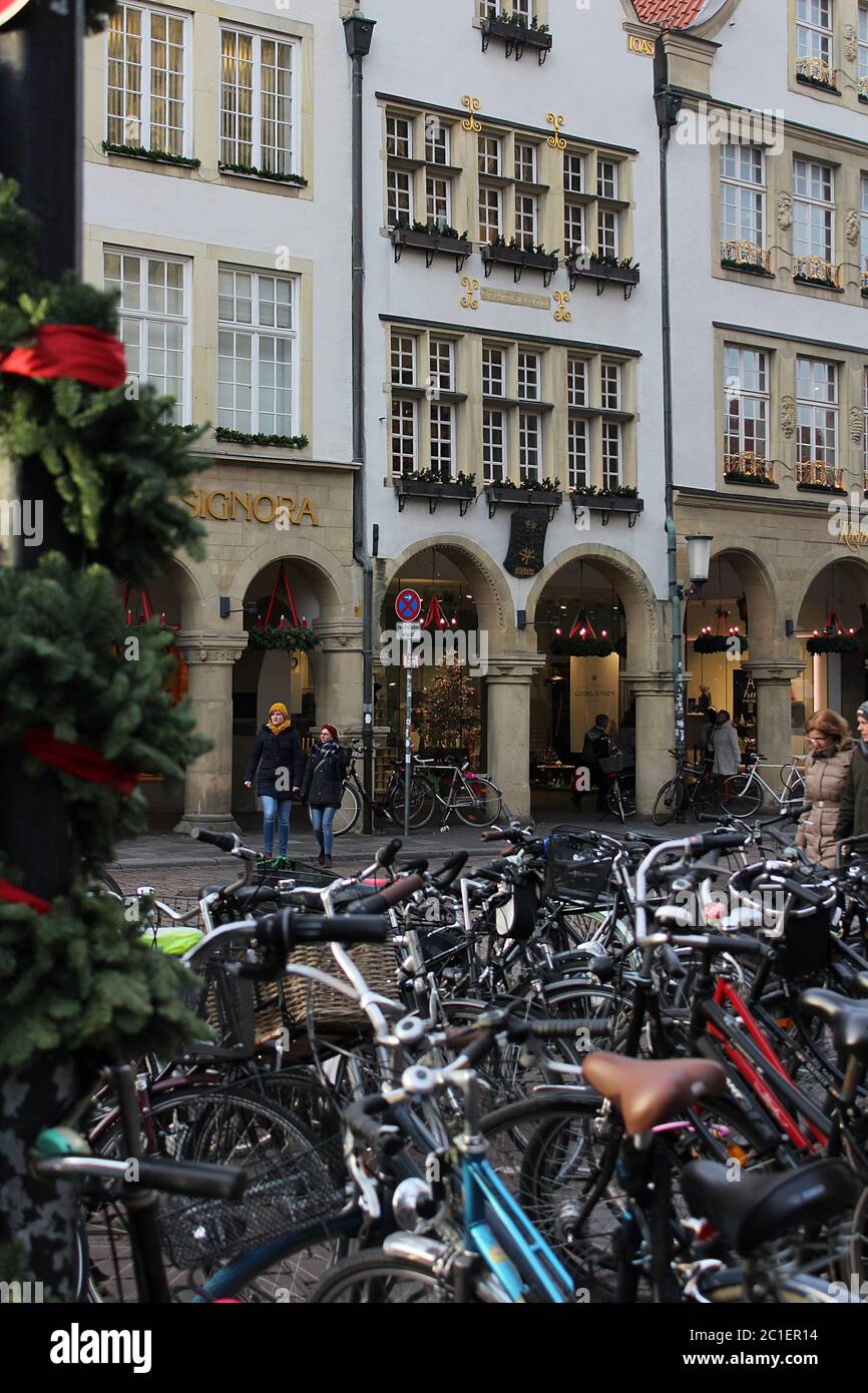 Christmas decorations in the streets of Muenster. People walking to the Christmas market along a row of parked bicycles. Festive, picturesque holiday. Stock Photo