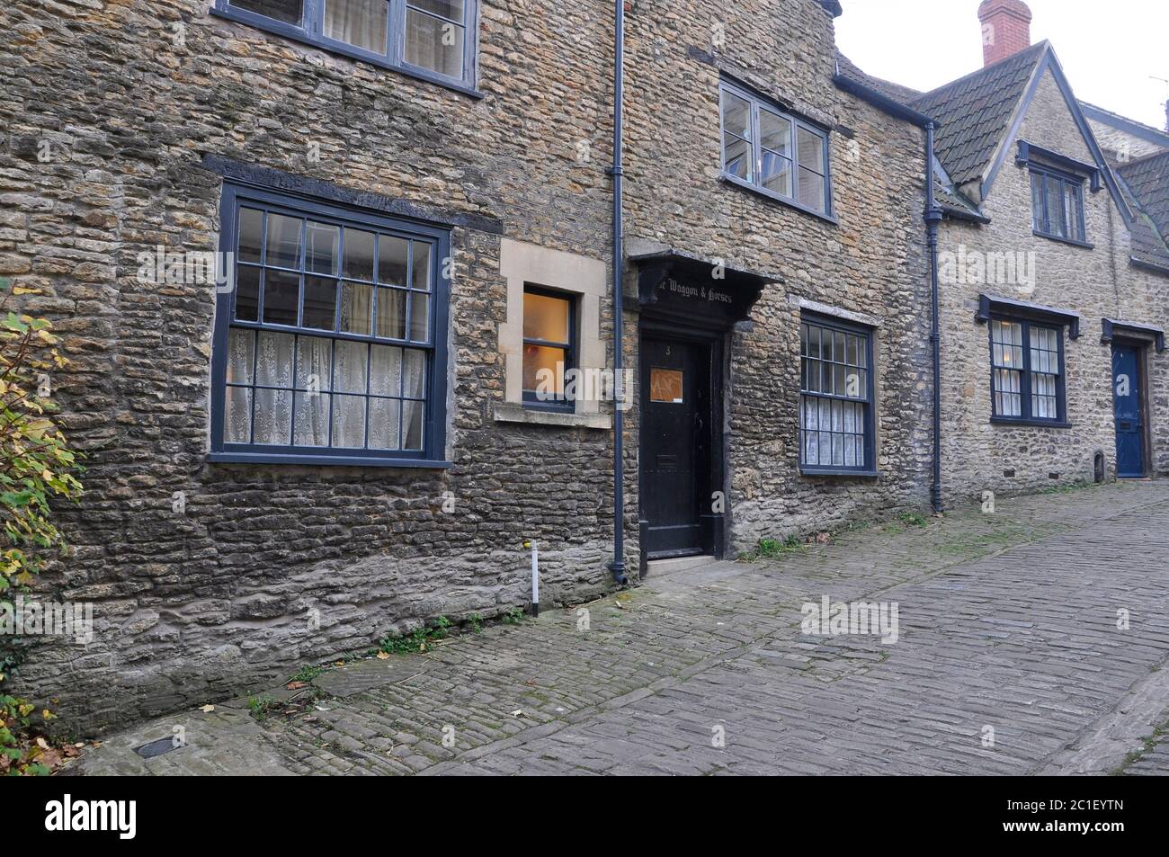 Gentle street, Frome.The steep cobbled street was the main road through the town.The Waggon and Horses Inn now a private dwelling.The street is used i Stock Photo