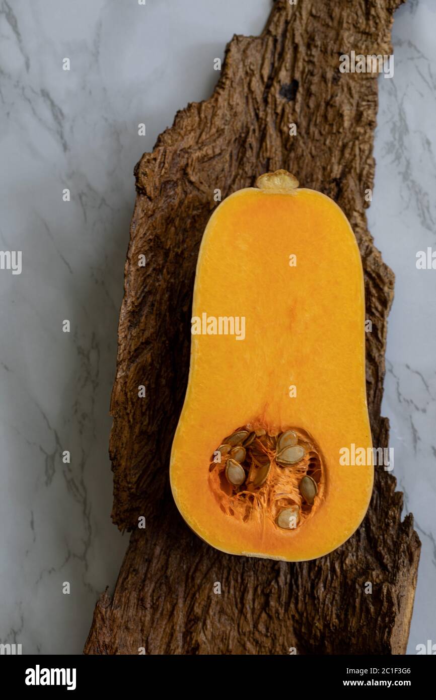 1/2 a butternut squash, laying on wood and marble background Stock Photo