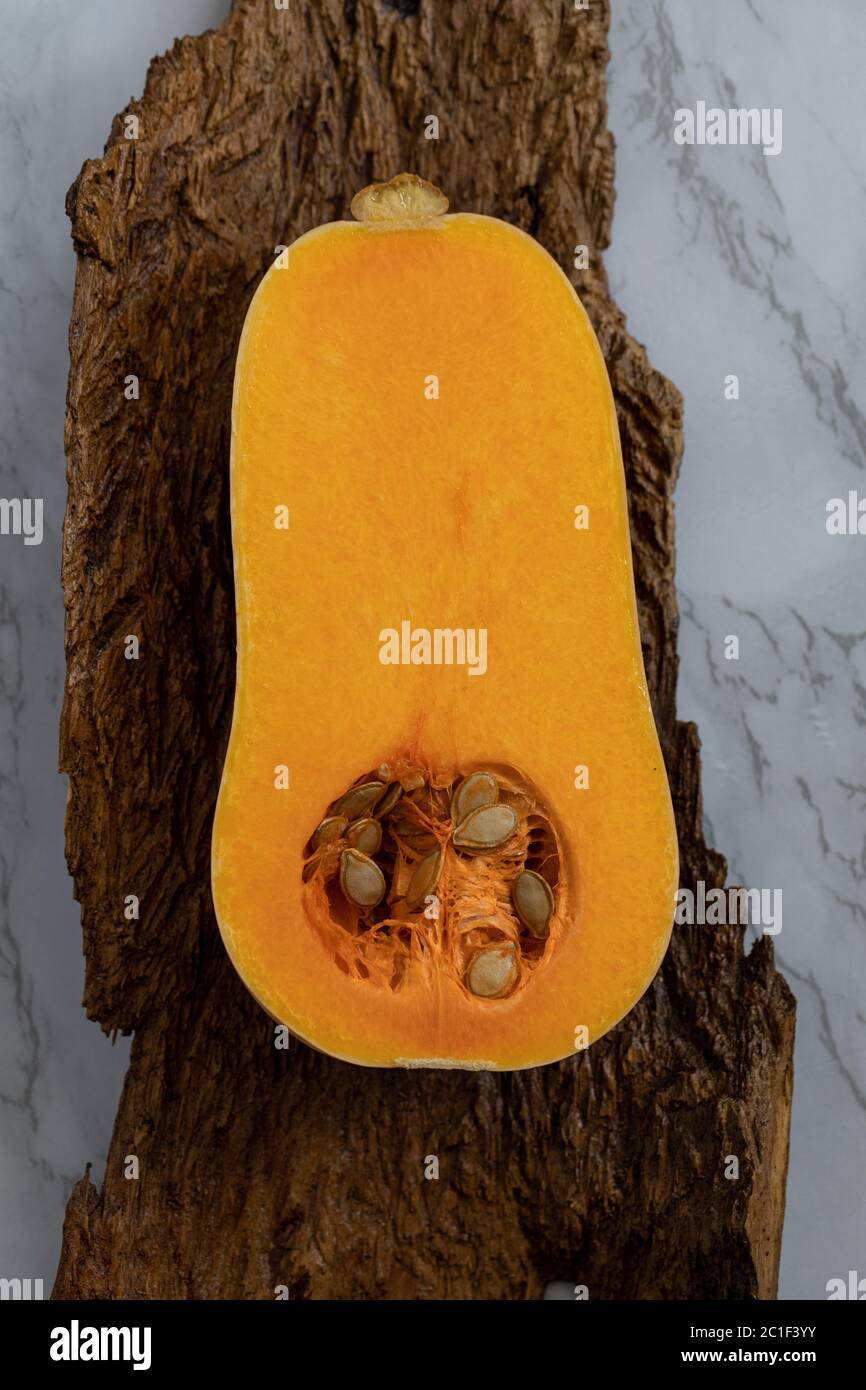 1/2 a butternut squash, laying on wood and marble background Stock Photo