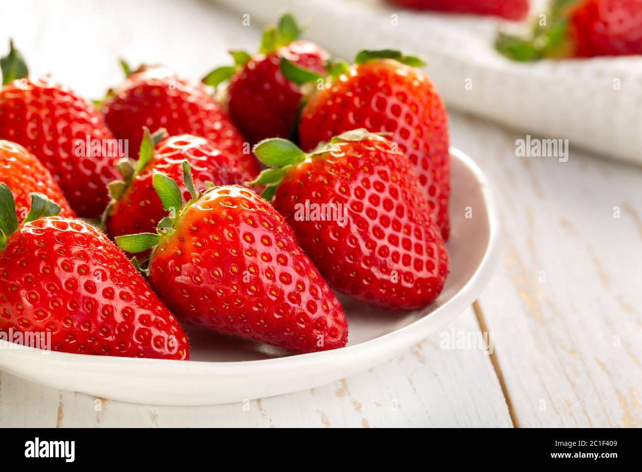 Cup of strawberries on white wooden background Stock Photo