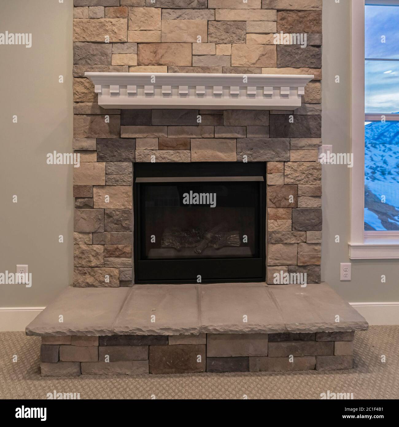 Square crop Fire insert in a feature stone brick wall Stock Photo