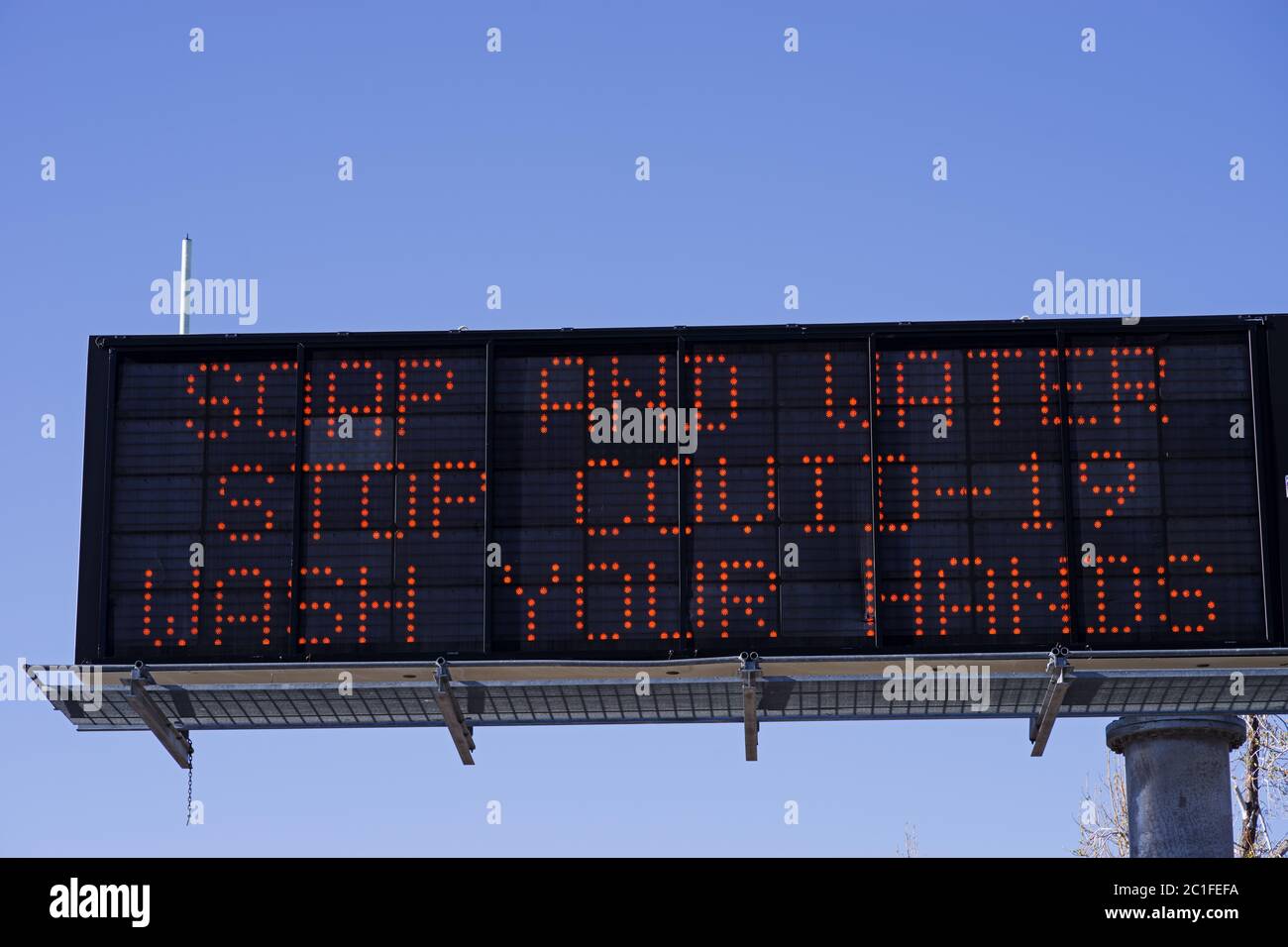 soap and water stop COVID-19 wash your hands highway warning sign Stock Photo
