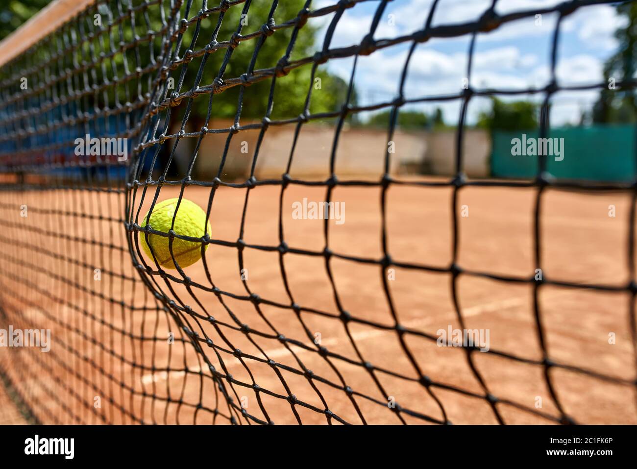 Yellow tennis ball in net Stock Photo Alamy