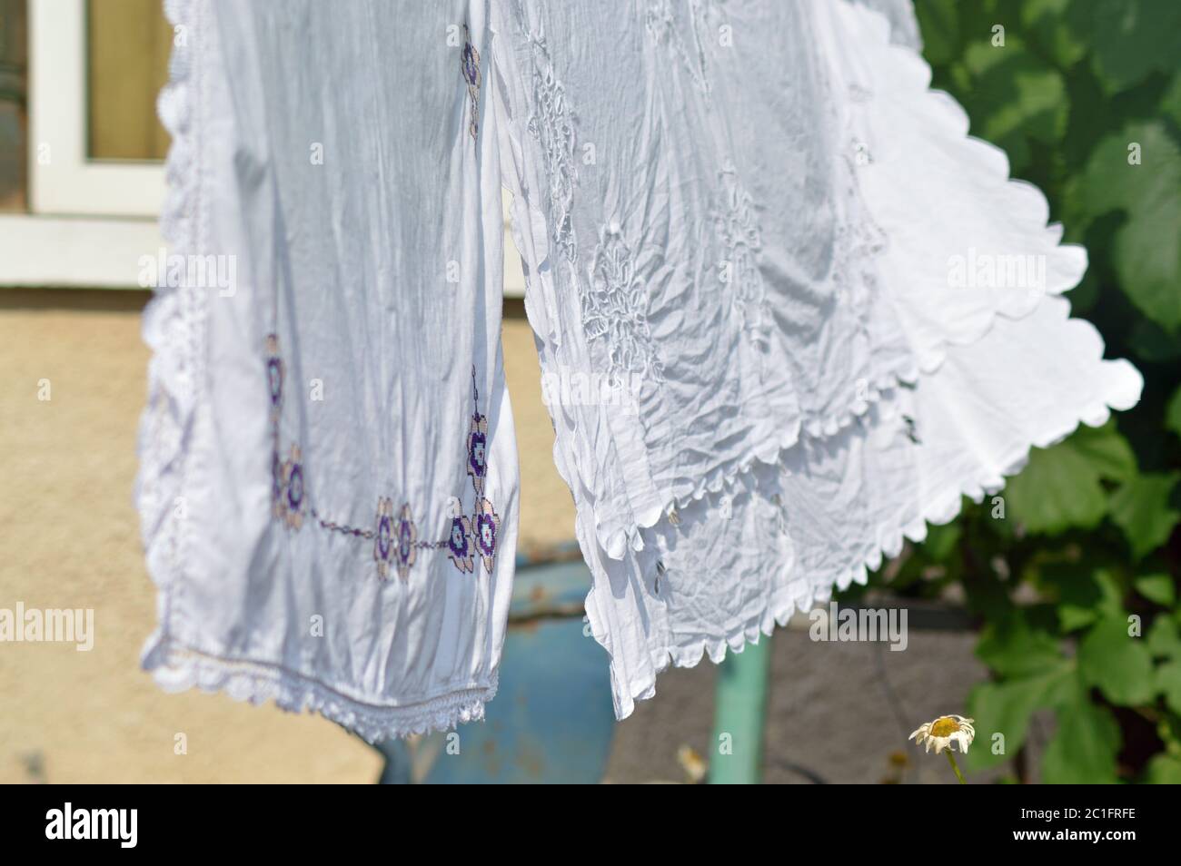 Traditional embroidered linen hanging on laundry rope Stock Photo