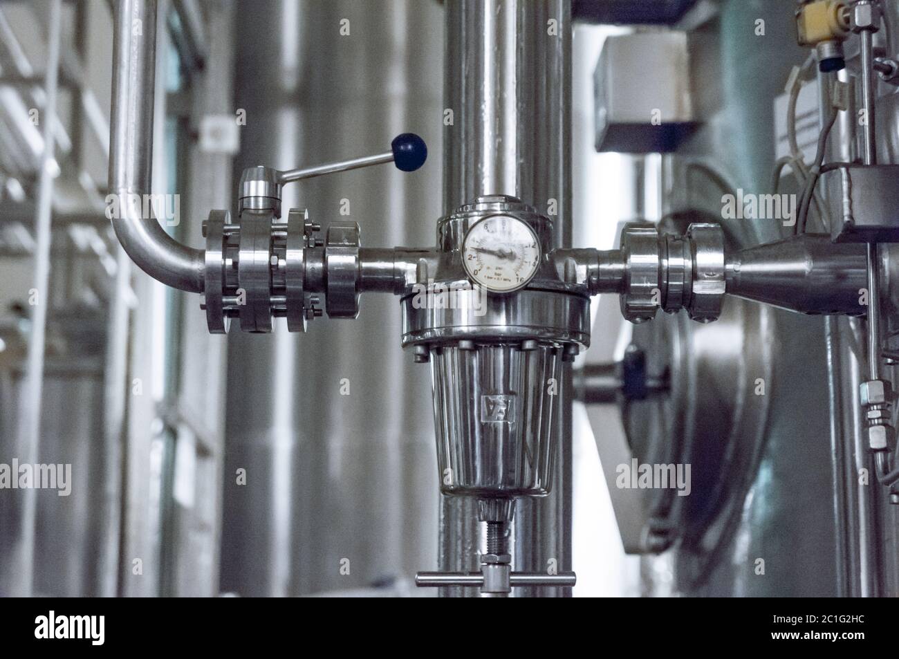 Industrial pressure meter barometer and water pipes in the background