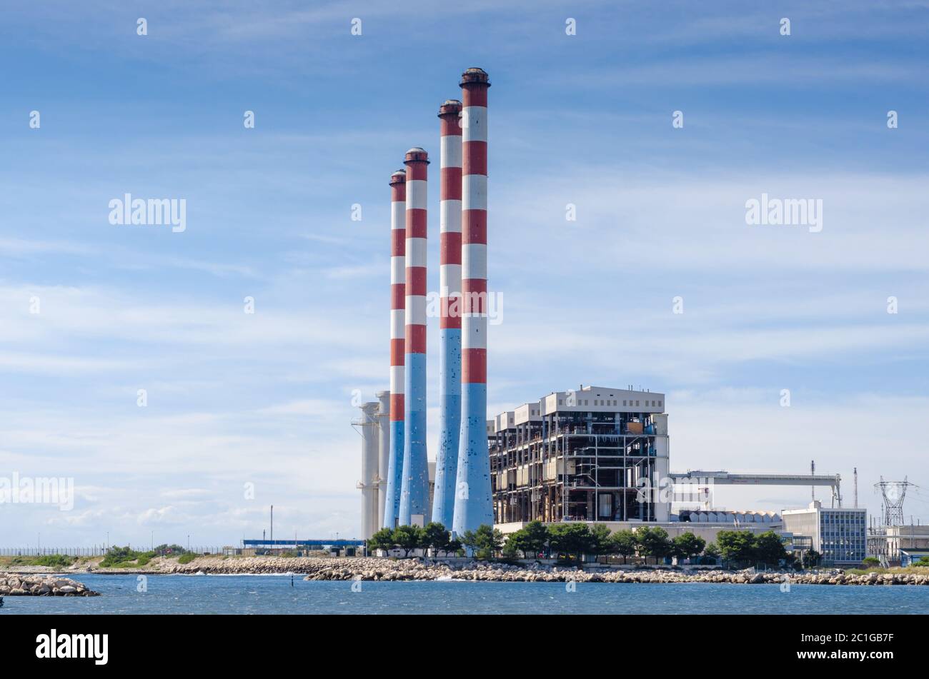 Martigues - France , vue de l'usine EDF de Martigues avec ses grandes cheminées bleues rouges et blanches au bord de l'etang de Berre Stock Photo