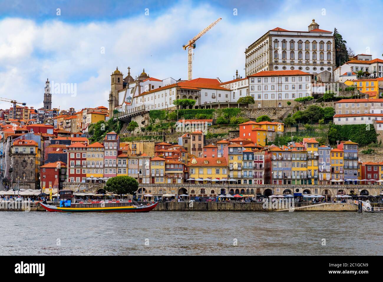 Porto, Portugal - May 30, 2018: View across the Douro onto the facades of traditional houses with azulejo tile in Ribeira and tourist rabelo boats Stock Photo