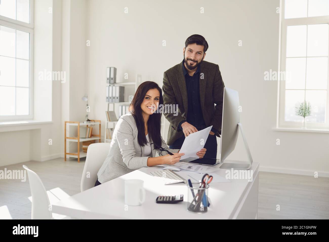 Business people smiling while standing in office. Stock Photo
