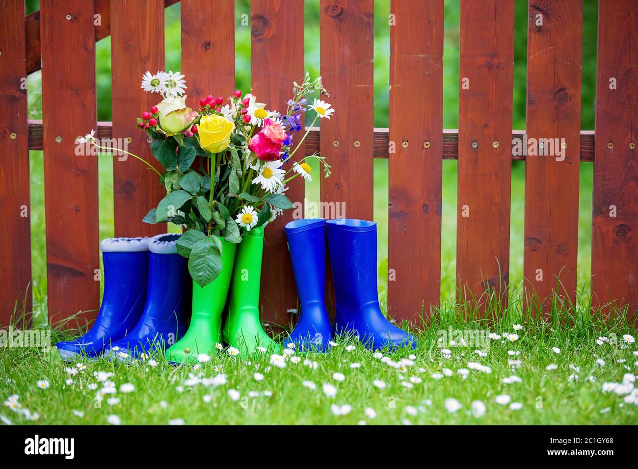 Rubber boots with beautiful flowers in garden Stock Photo - Alamy