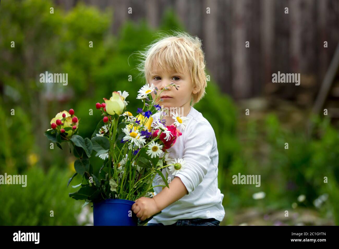 Child holding rubber boots with beautiful flowers in garden Stock Photo ...