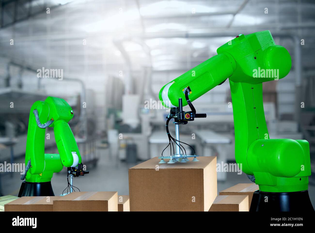 The Robotic arms carries cardboard box for delivery industry packing Stock Photo