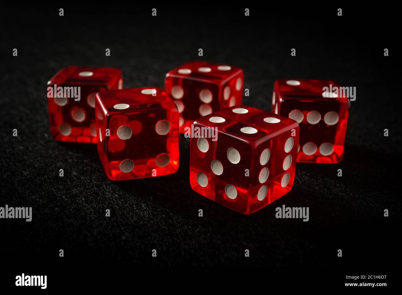 red dice on black felt Stock Photo