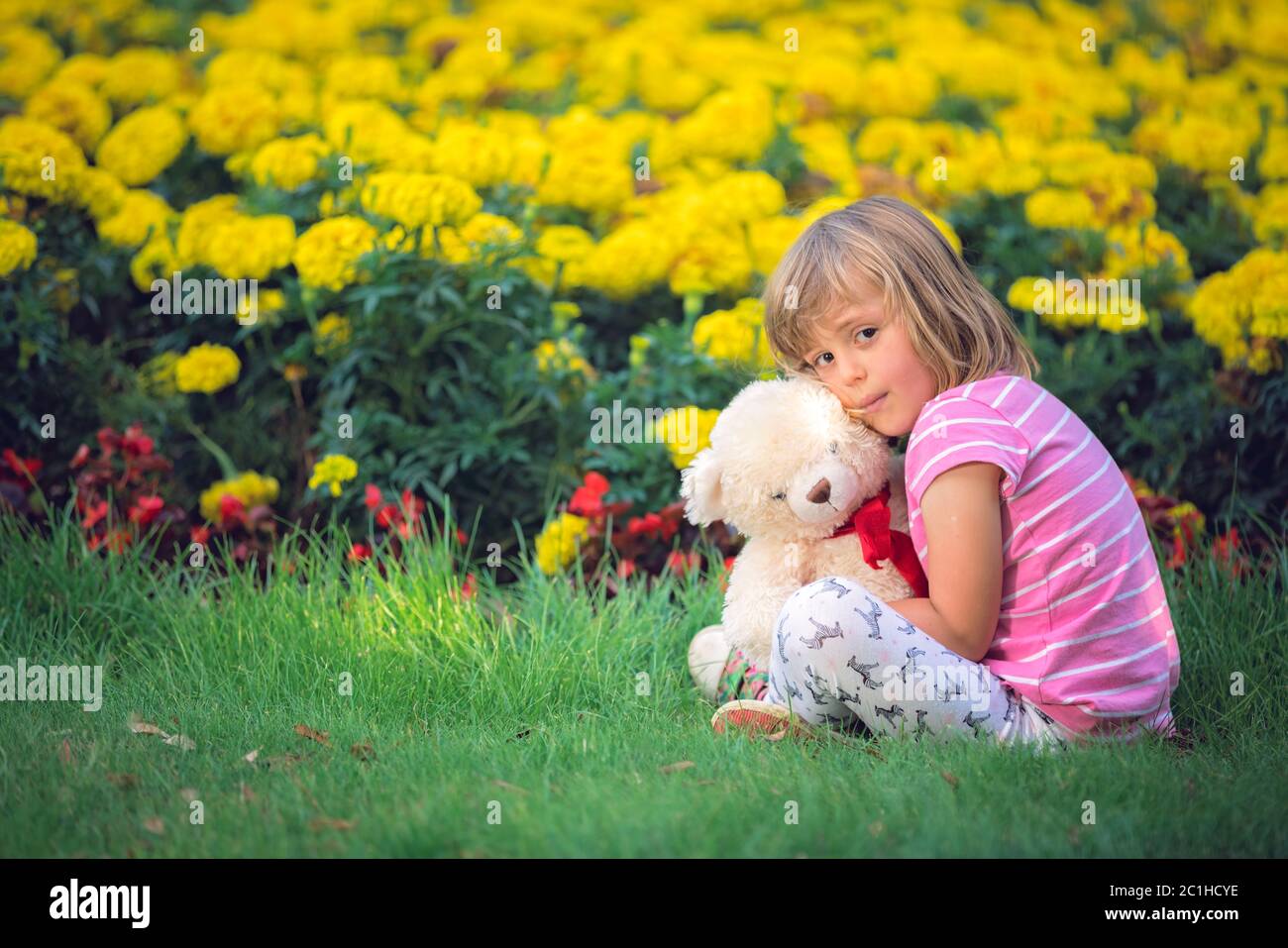 Adorable girl hugging her teddy bear in summer park Stock Photo - Alamy