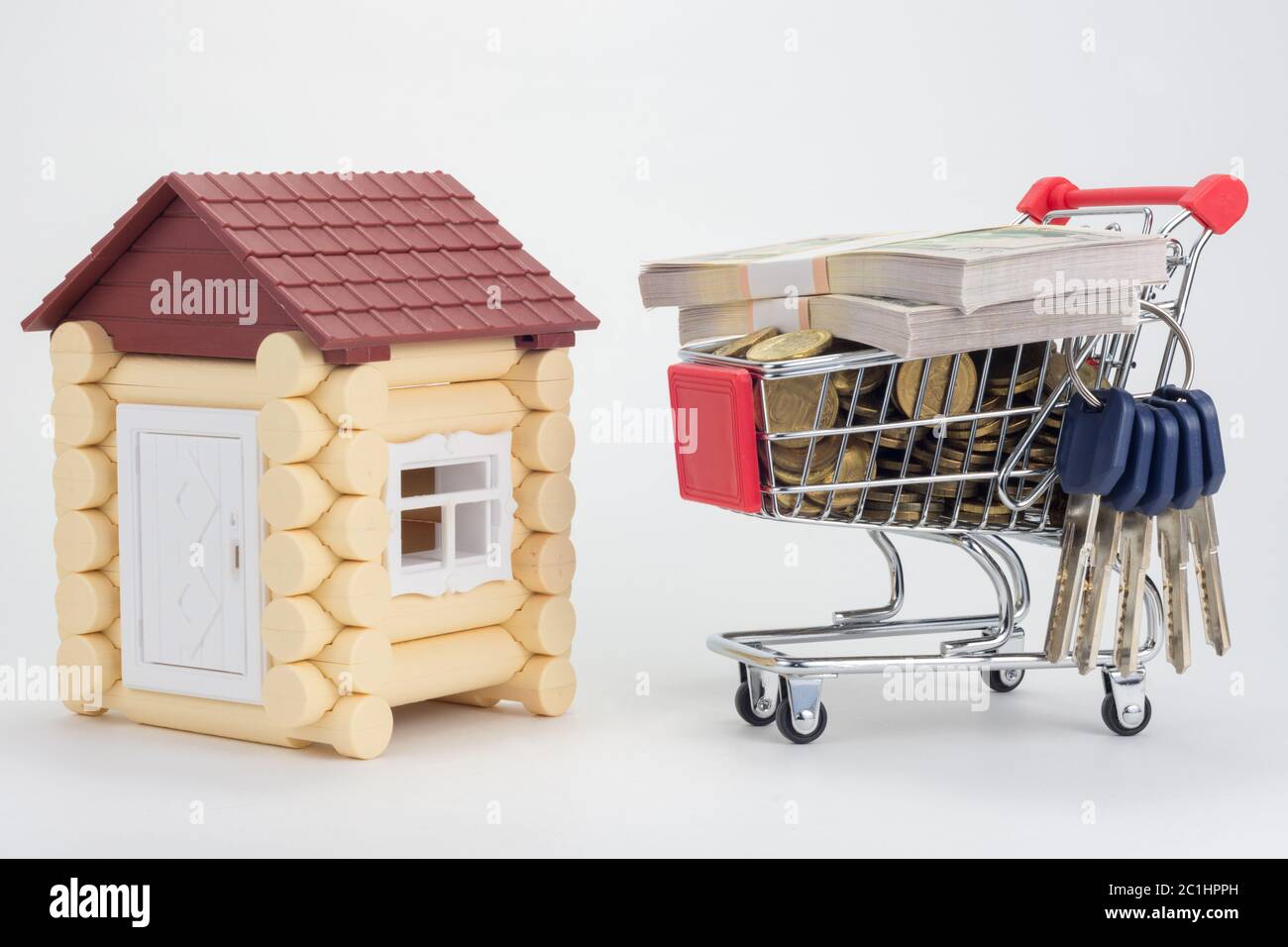 Toy house, trolley with money and a bunch of keys to the house Stock Photo