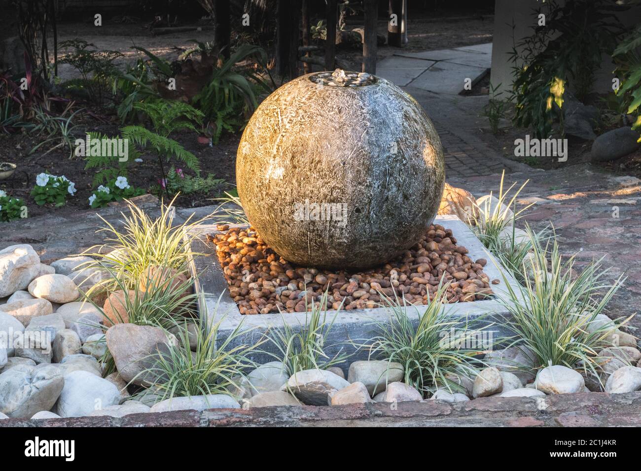 Water fountain made of concrete in garden at sunset Stock Photo