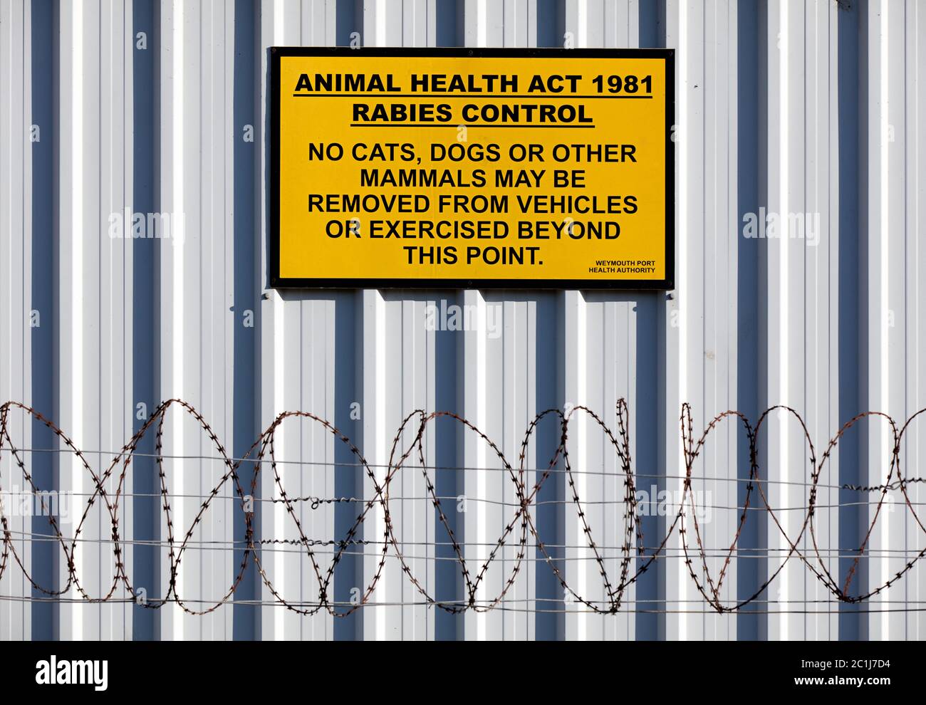 Old rabies control sign at the ferry terminal in Weymouth, Dorset. Stock Photo