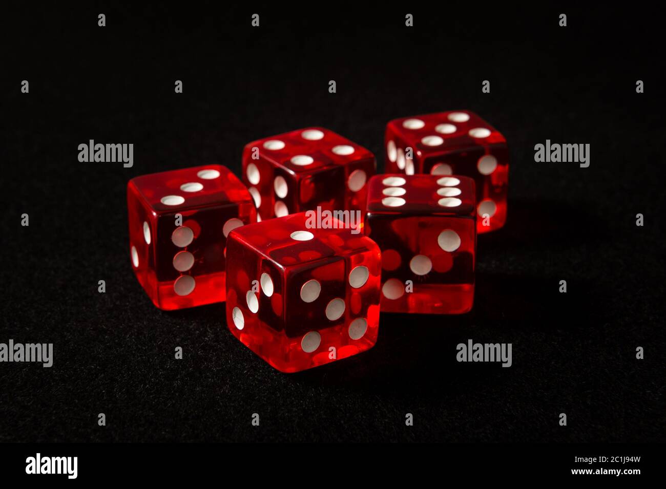 red dice on black felt Stock Photo