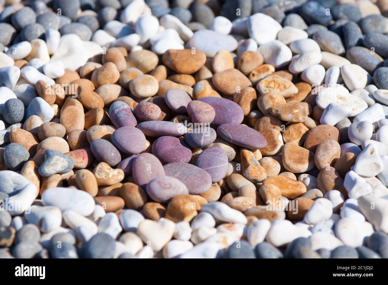 Chesil Beach, Dorset - Colourful beach pebbles arranged into concentric circles for fun and relaxation on a summertime day trip to the seaside. Stock Photo