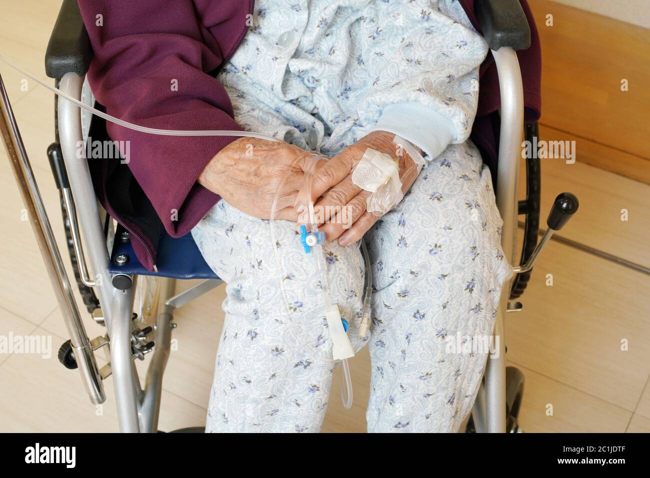 elderly woman hands with intravenous drip on a wheelchair at hospital Stock Photo
