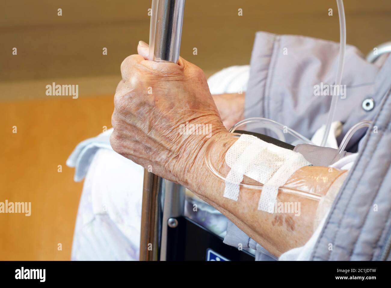 Close up of elderly woman hands with intravenous drip on a wheelchair Stock Photo