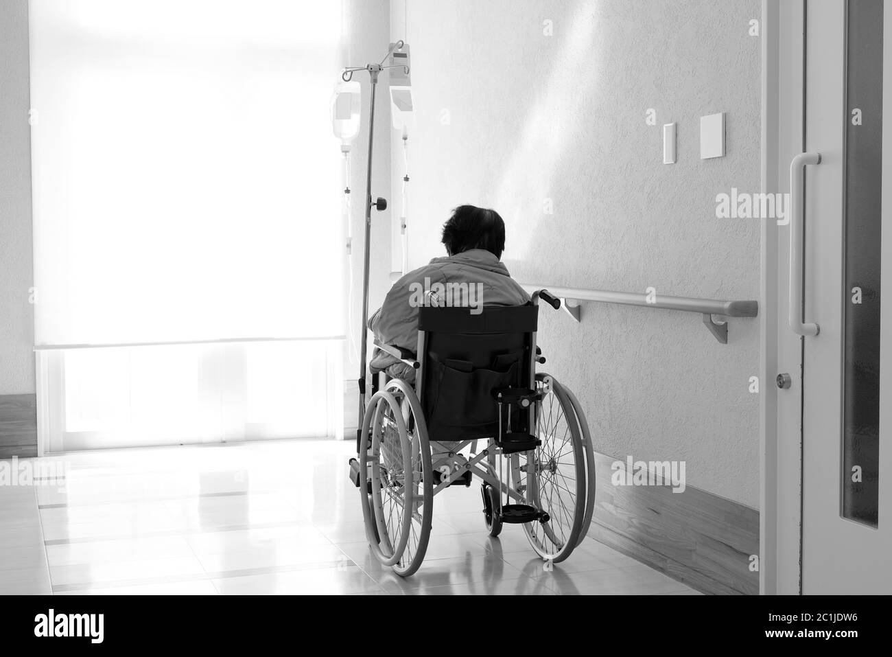 Back view of senior or elderly woman on wheelchair at hospital hallway Stock Photo