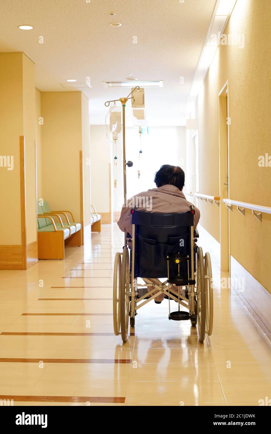 Back view of senior or elderly woman on wheelchair at hospital hallway Stock Photo