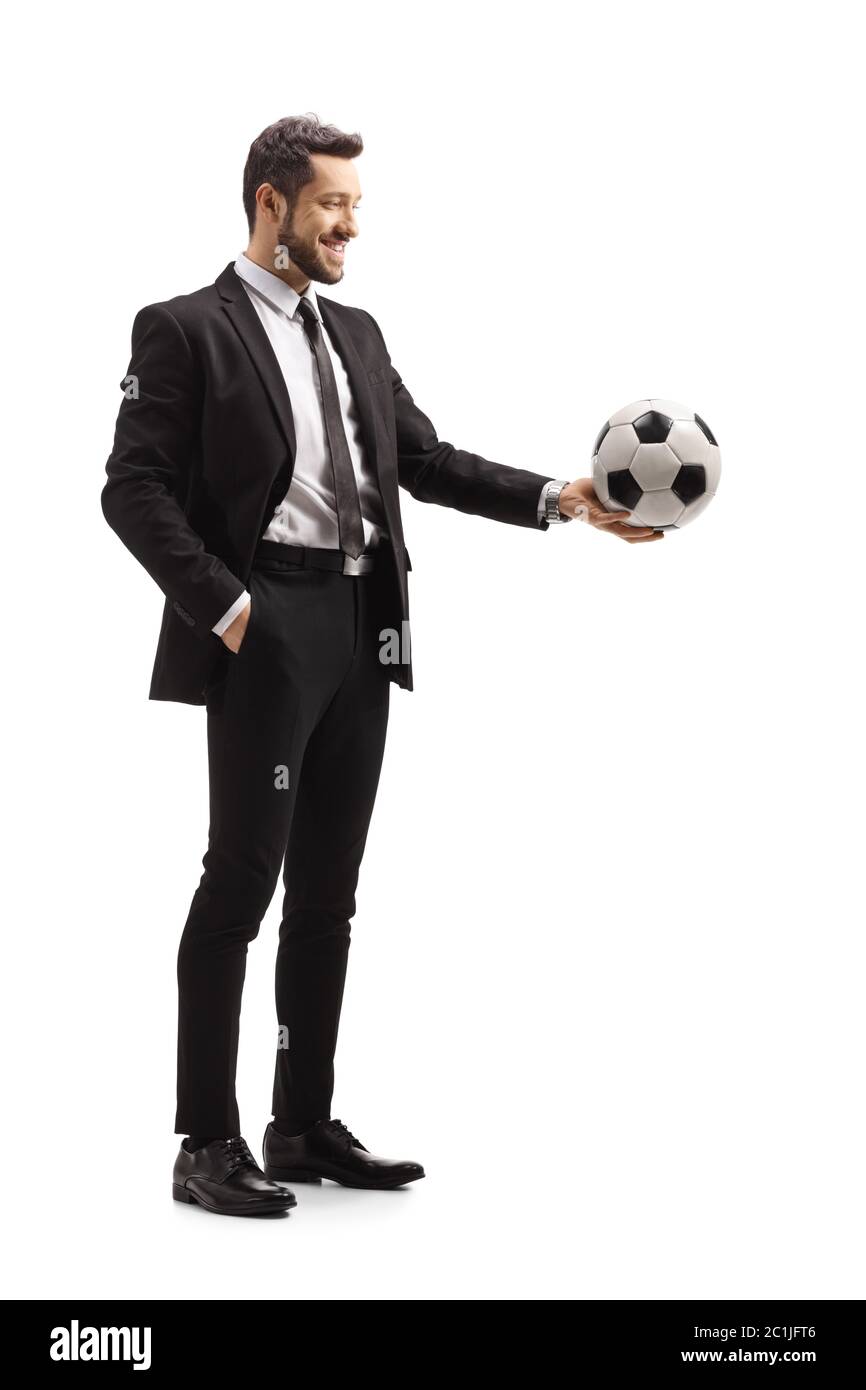 Full length shot of a man in a suit holding a soccer ball isolated on ...