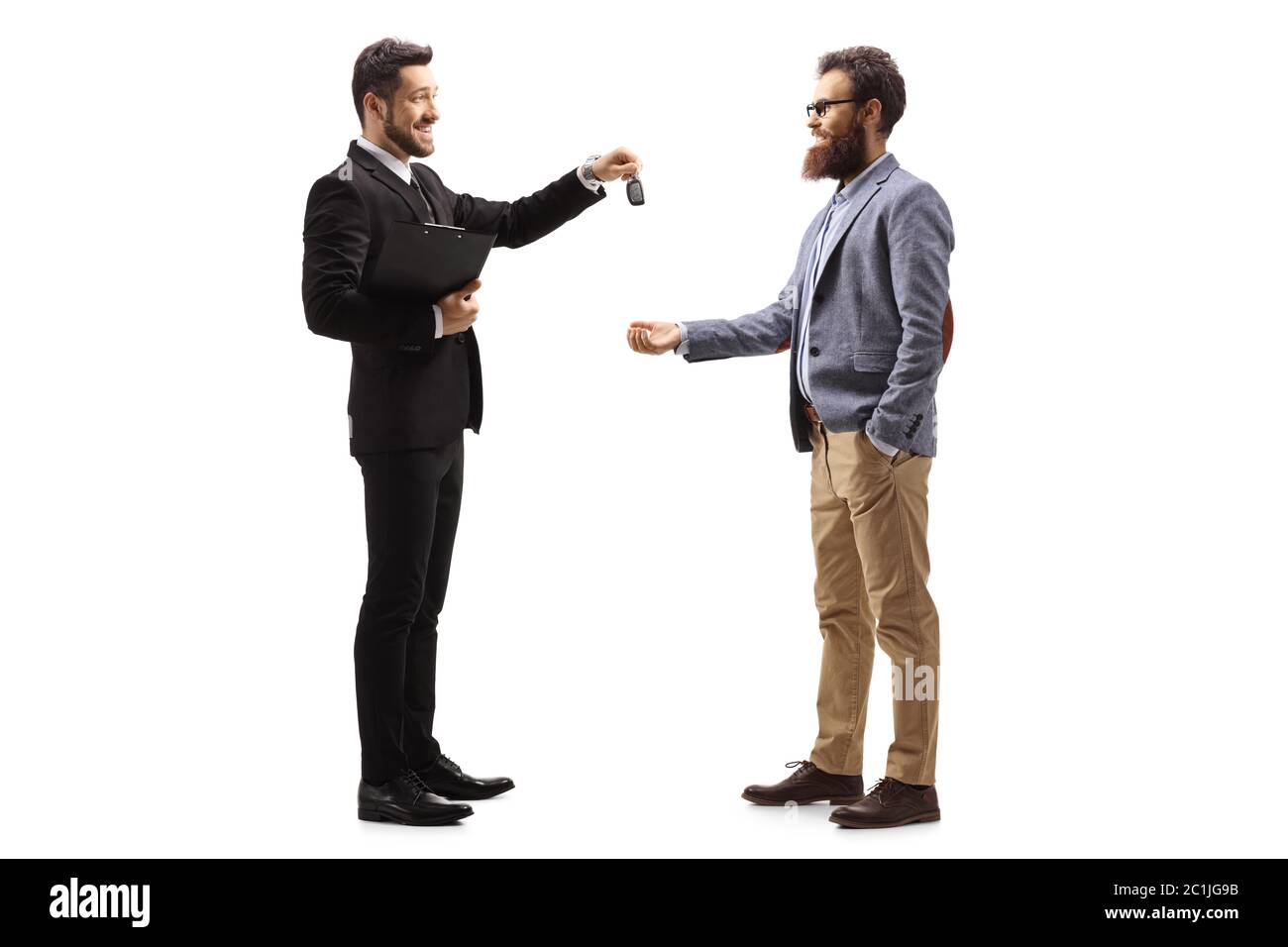 Full length profile shot of a businessman giving car keys to a smiling bearded man isolated on white background Stock Photo